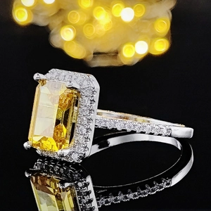 Luxurious silver ring with large rectangular yellow gemstone and pave diamond accents