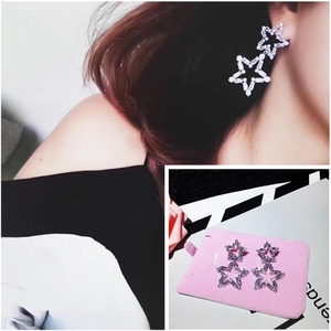 Detail of silver hollow double star earrings with pavé crystals on a pink velvet stand