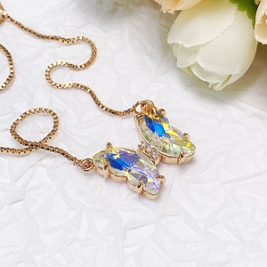 Macro detail of rose gold butterfly pendant with gradient crystal and zircon stones