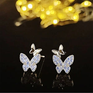 Gros plan détaillé de boucles d'oreilles papillon en argent avec zircons violets sertis