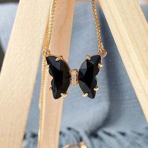 Macro shot of faceted black butterfly pendant with gold claw setting and cubic zirconia