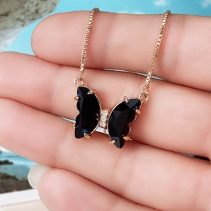 Rose gold butterfly necklace with black gemstone wings and sparkling micro-inlaid stones