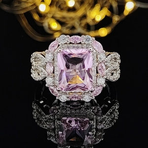 Exaggerated cocktail ring with large pink rectangular gem and halo pavé setting