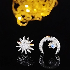 Boucles d'oreilles asymétriques étoile et lune en argent avec zircons bleus sur miroir noir