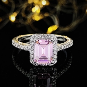 Elegante ring met smaragdgeslepen roze edelsteen en diamanten halo op zwarte basis