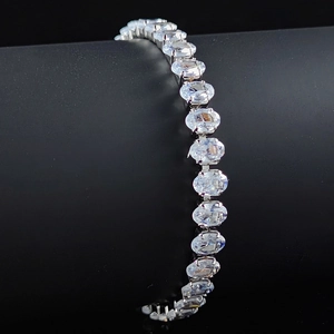 Macro di bracciale tennis in argento con zirconi ovali su un supporto nero