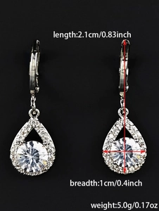Vue détaillée des boucles d'oreilles goutte avec zircon central et serti halo argenté