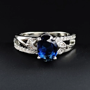 Dettaglio dell'anello in pizzo argento con zircone blu ovale e motivo a foglia