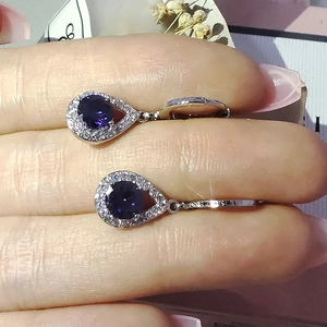 Vue détaillée des boucles d'oreilles goutte violettes avec cristaux et plaquage argent