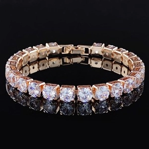 Dettaglio del bracciale tennis oro rosa con grandi cristalli trasparenti su sfondo nero