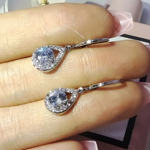 Gros plan de boucles d'oreilles en forme de larme avec pierres rondes et sertissage pavé