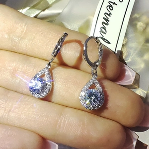 Détail macro de boucles d'oreilles poires en argent avec cristaux brillants sertis en halo