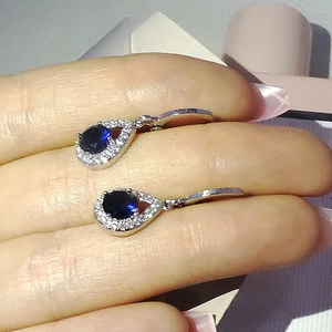 Détail des boucles d'oreilles goutte avec cristaux bleus et pavage en zircone blanc