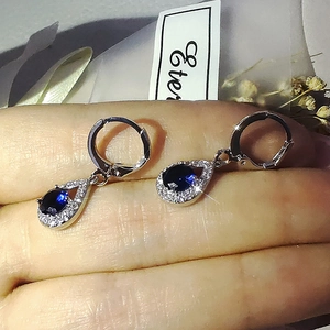 Vue détaillée de boucles d'oreilles goutte avec pierres bleues et fermoirs argentés