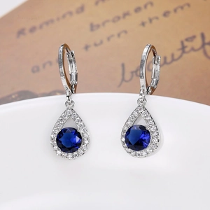 Détail macro de boucles d'oreilles en goutte avec pierres bleu foncé et fermoir levier