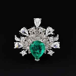 Irregular silver ring featuring pear-cut emerald and white zircon starburst design