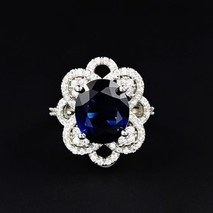 Adjustable floral sapphire ring with halo diamonds on a polished silver band