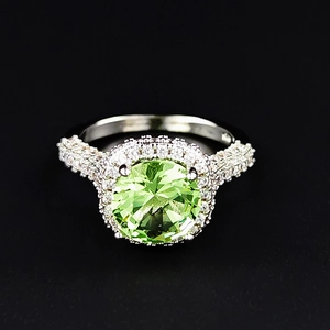 Classic silver ring with a large round green gemstone surrounded by white diamonds