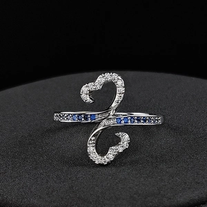 Macro shot of silver-colored butterfly ring with zircon inlays and blue stones