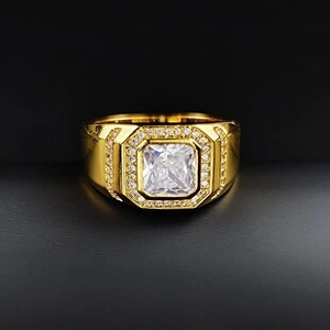 Vue macro de la bague dorée avec zircon carré et pavé de diamants sur fond noir élégant