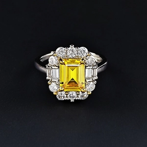 Bague de luxe avec pierre jaune taille émeraude et halo de diamants sur métal poli