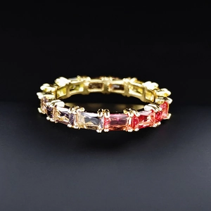 Vue détaillée d'une bague dorée sertie de pierres colorées dégradées taille baguette