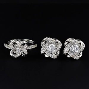 Détail d'une parure de bijoux argentés avec nœuds entrelacés et pierres de zircone