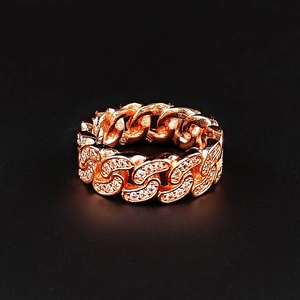 Bague chaîne cubaine or rose ornée de cristaux scintillants sur un fond noir pur