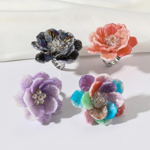 Colorful resin flower rings with crystal centers on a metallic adjustable base