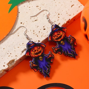 Close-up of Halloween pumpkin earrings with purple hats on textured stone display