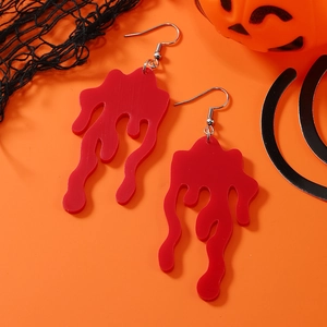 Gruselige Halloween-Ohrringe in Blutstropfen-Optik auf orangefarbenem Hintergrund