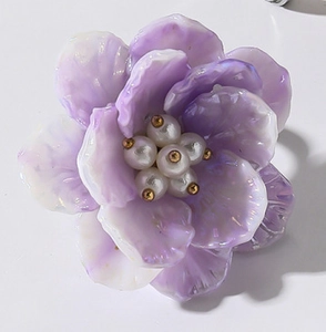 Detalle macro de anillo de flor de resina púrpura con pétalos degradados y perlas