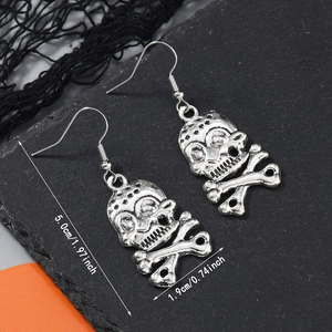 Détail de boucles d'oreilles squelette gothiques en argent antique sur ardoise foncée