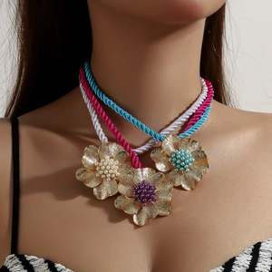 Detailaufnahme der geflochtenen Seilhalskette mit drei farbenfrohen Metall-Blumenanhängern