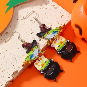 Detail view of Halloween acrylic earrings featuring a green witch frog and magic cauldron
