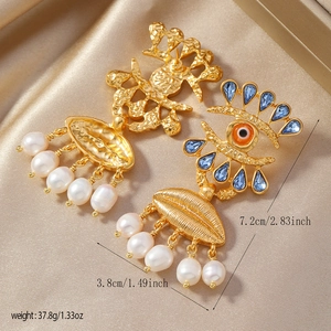 Détail de boucles d'oreilles vintage œil d'or avec pierres bleues et perles blanches