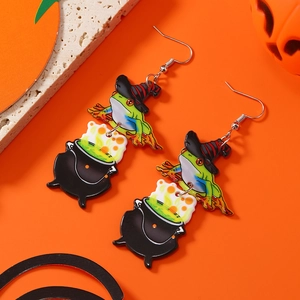 Detail of Halloween frog wizard earrings featuring a green frog with a cauldron on orange background
