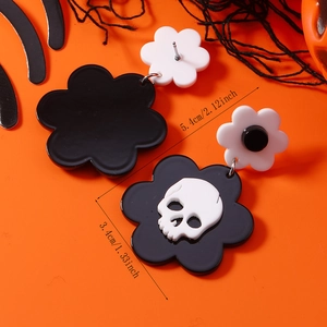 Pendientes punk Halloween de flores y calavera en blanco y negro sobre fondo de telaraña