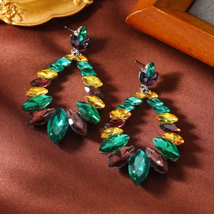 Détail macro de boucles d'oreilles vintage avec strass marquise colorés sur de la soie