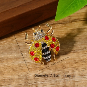 Detail macro-opname van een kristallen lieveheersbeestje broche met afmetingen en gewicht