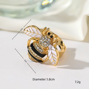 Detailopname van een vintage bijenring met witte emaille vleugels en fonkelende strass