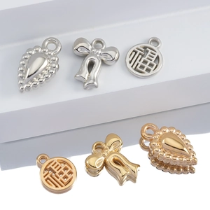 Detail of CCB charms including teardrop bow and Fu character in gold and silver