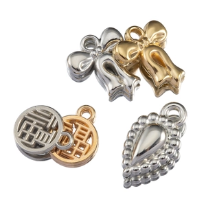 Macro detail of gold and silver bow, fortune, and water drop CCB charms for DIY jewelry making