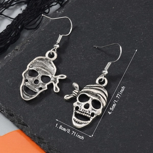 Détail des boucles d'oreilles crâne en argent antique montrant la taille et le style