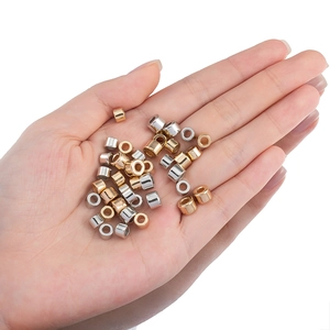 Goldene und silberne zylindrische Abstandsperlen für DIY-Schmuck auf einer Handfläche