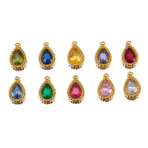 Vue macro de pendentifs goutte en strass multicolores avec sertissage en métal doré