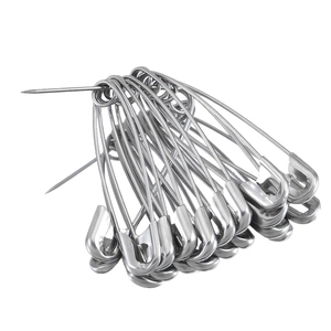 Close-up of several silver stainless steel safety pins with polished metallic texture