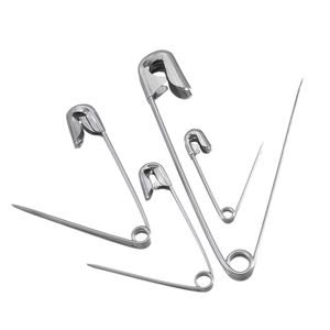 Detail of assorted silver stainless steel safety pins in four different sizes on white background