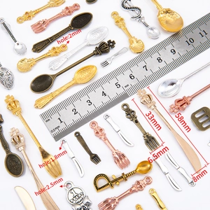 Detailed size measurement of vintage alloy cutlery pendants with ruler and scale markings