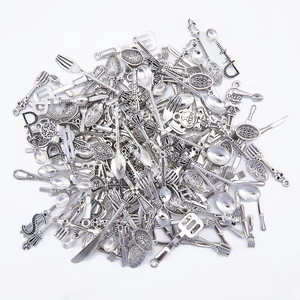 Macro view of vintage silver alloy cutlery charms featuring baroque style embossed patterns